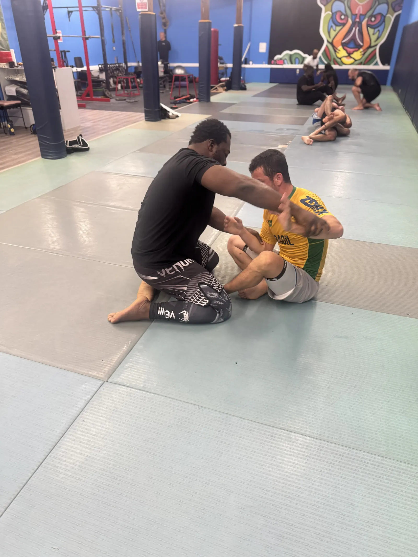 Coach working one-on-one with an adult student during an adult Brazilian Jiu Jitsu class at Elijah Brazilian Jiu Jitsu Academy in Union, New Jersey
