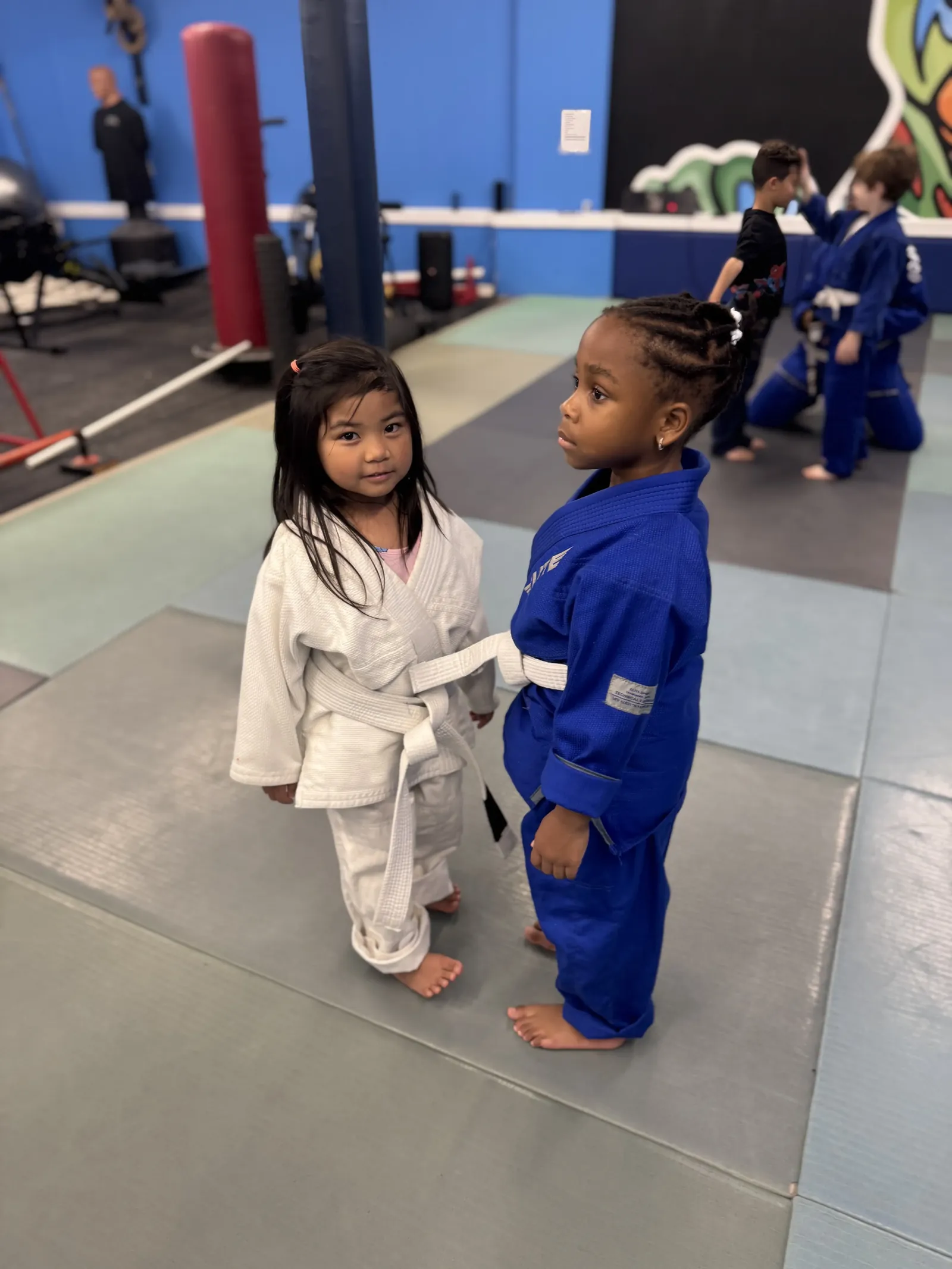 Kids in white and blue gis facing off during class at Elijah Brazilian Jiu Jitsu Academy